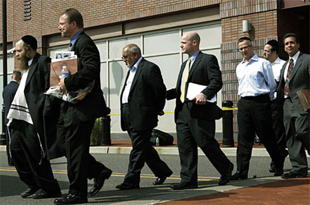 A group of unidentified men walk outside FBI offices Thursday in Newark, N.J., on their way to a bus for their court hearing